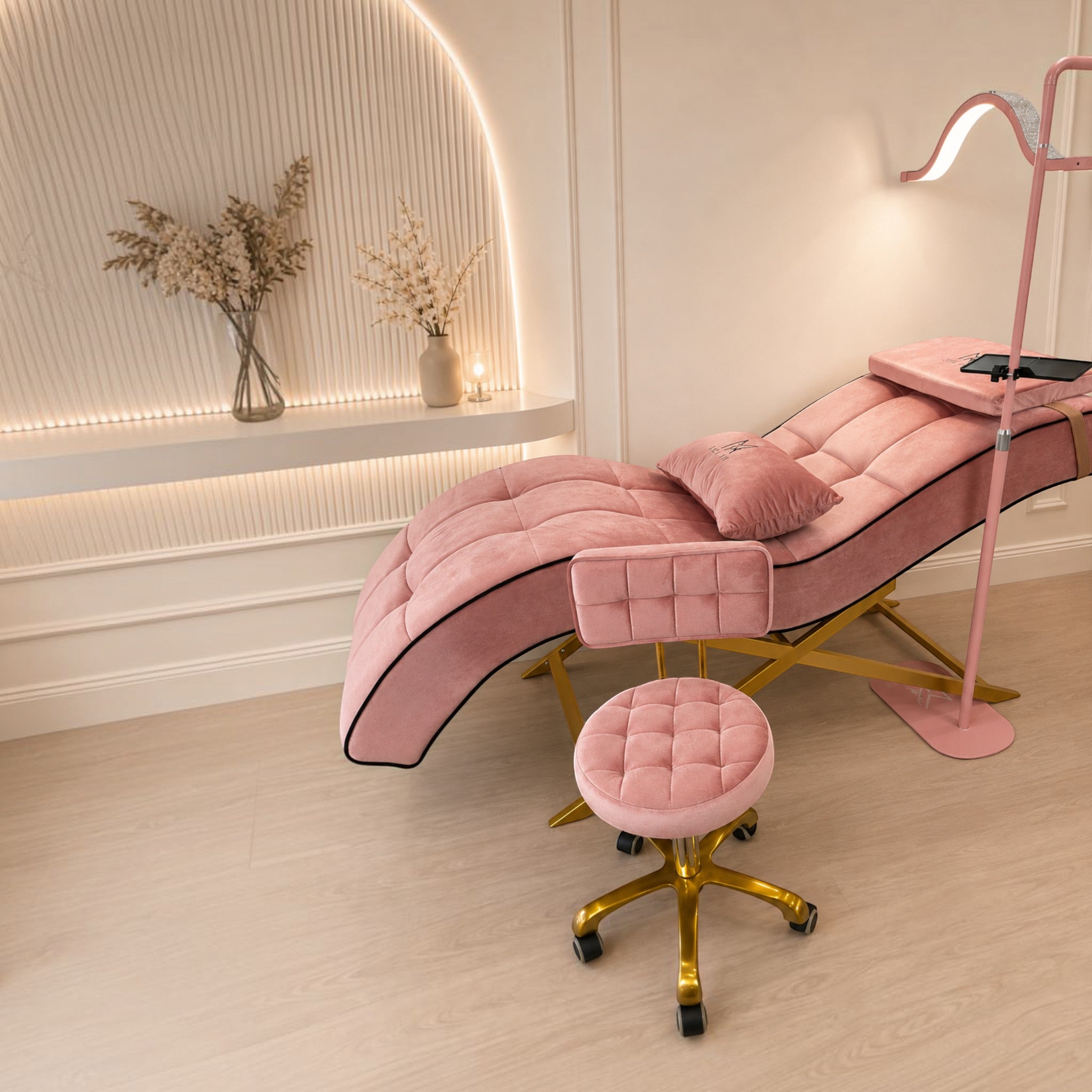 MK BEAUTY BED All in One Curved Bed in pink velvet with gold X-cross base and matching stool in a salon setting