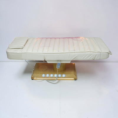 MK BEAUTY BED luxury electric treatment bed in white PU leather with a wooden base and handheld remote control.