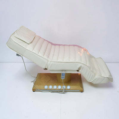 MK BEAUTY BED luxury electric treatment bed in white PU leather with a wooden base and handheld remote control.